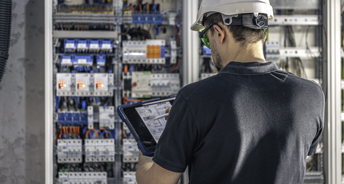 Eletricista da MARFULL trabalhando em quadro de distribuição elétrica